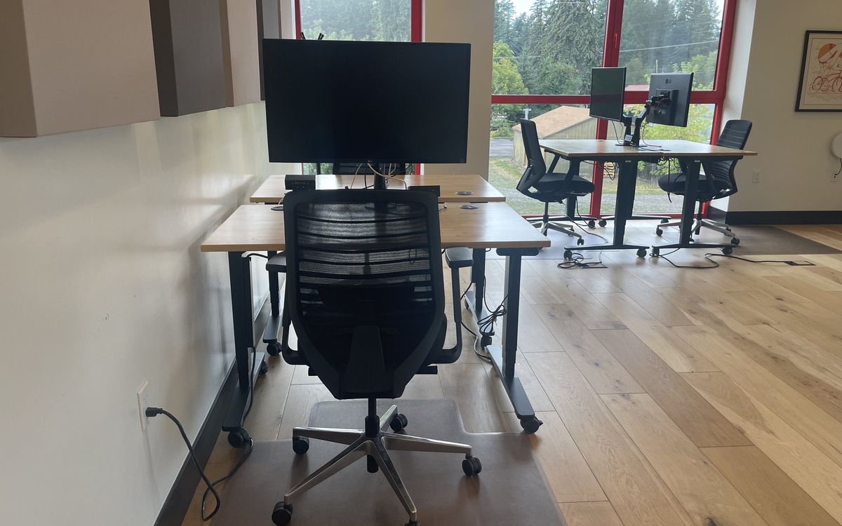 A dedicated desk on the upstairs floor with a 32-inch 4K monitor and task chair