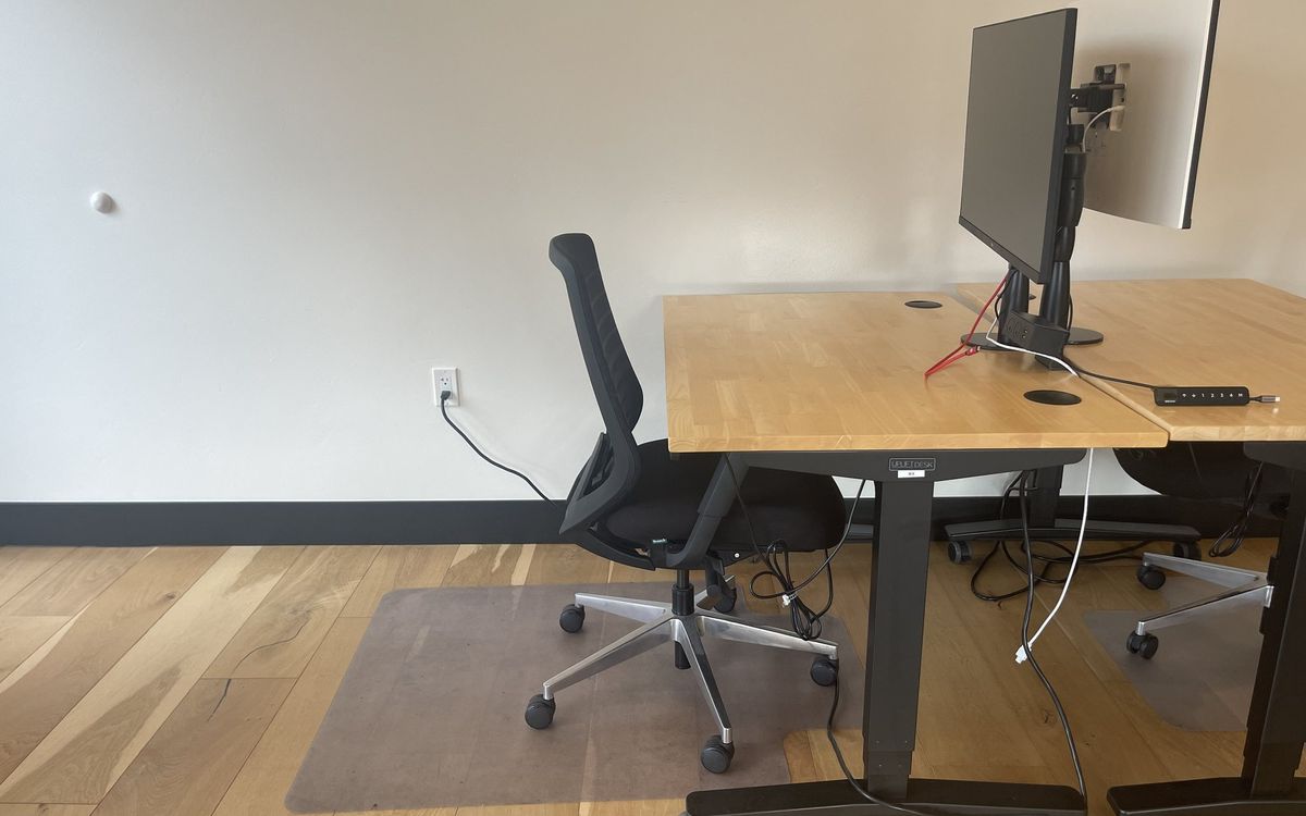 A dedicated desk on the upstairs floor with a 32-inch 4K monitor and task chair