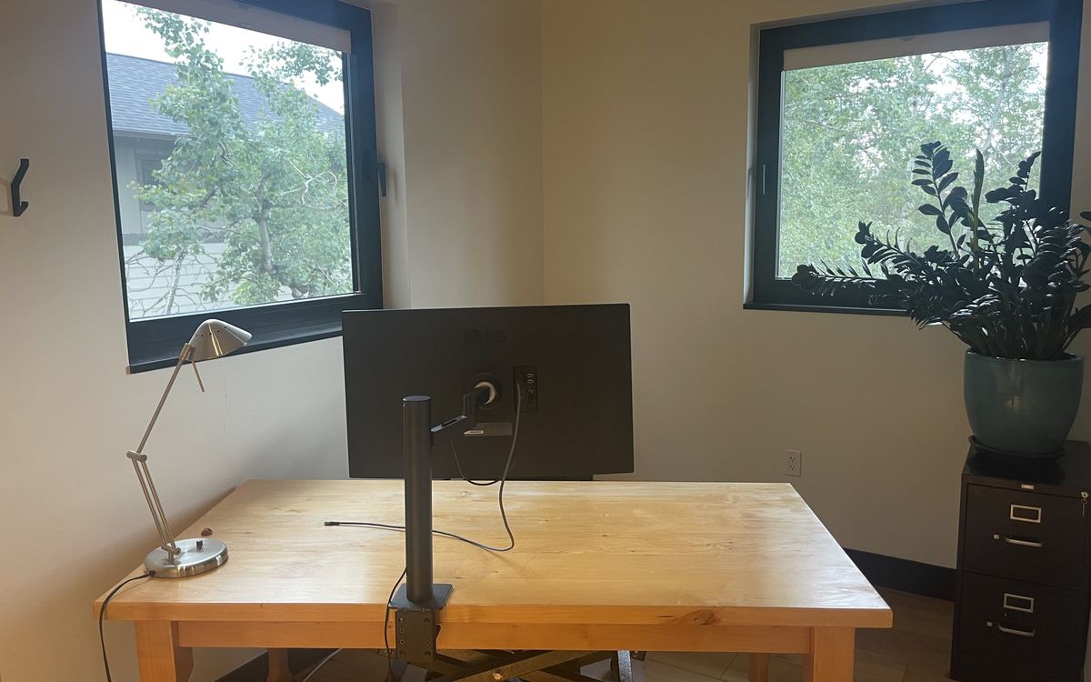 Private Office 10 upstairs — a wooden desk with a monitor, desk lamp and a plant