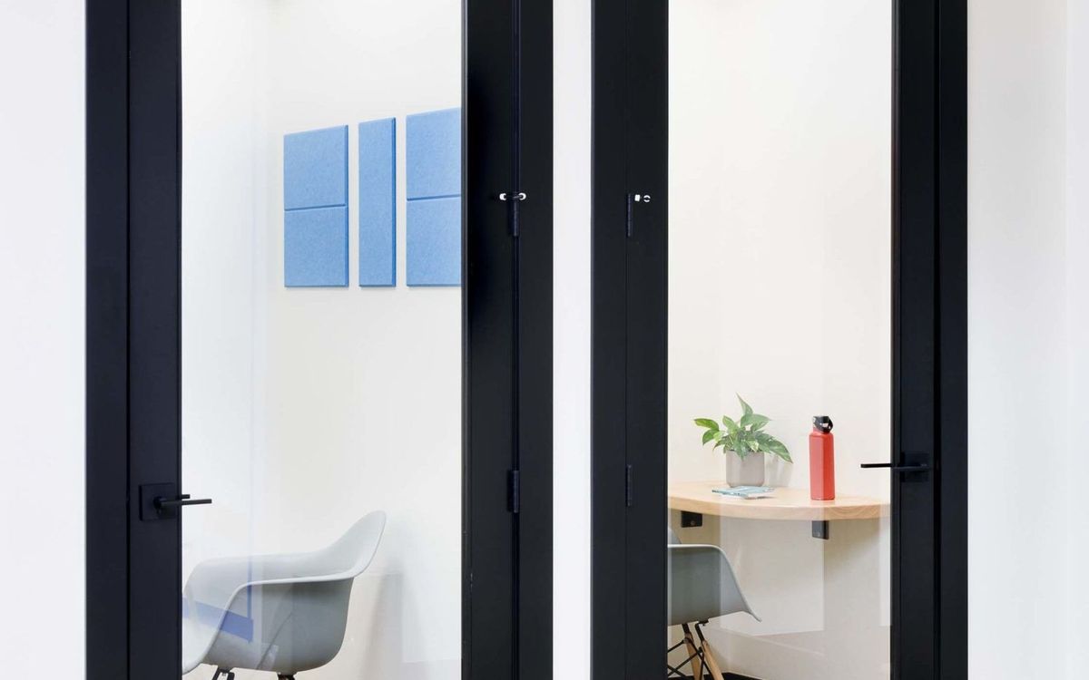 A phone booth with a small desk and chair