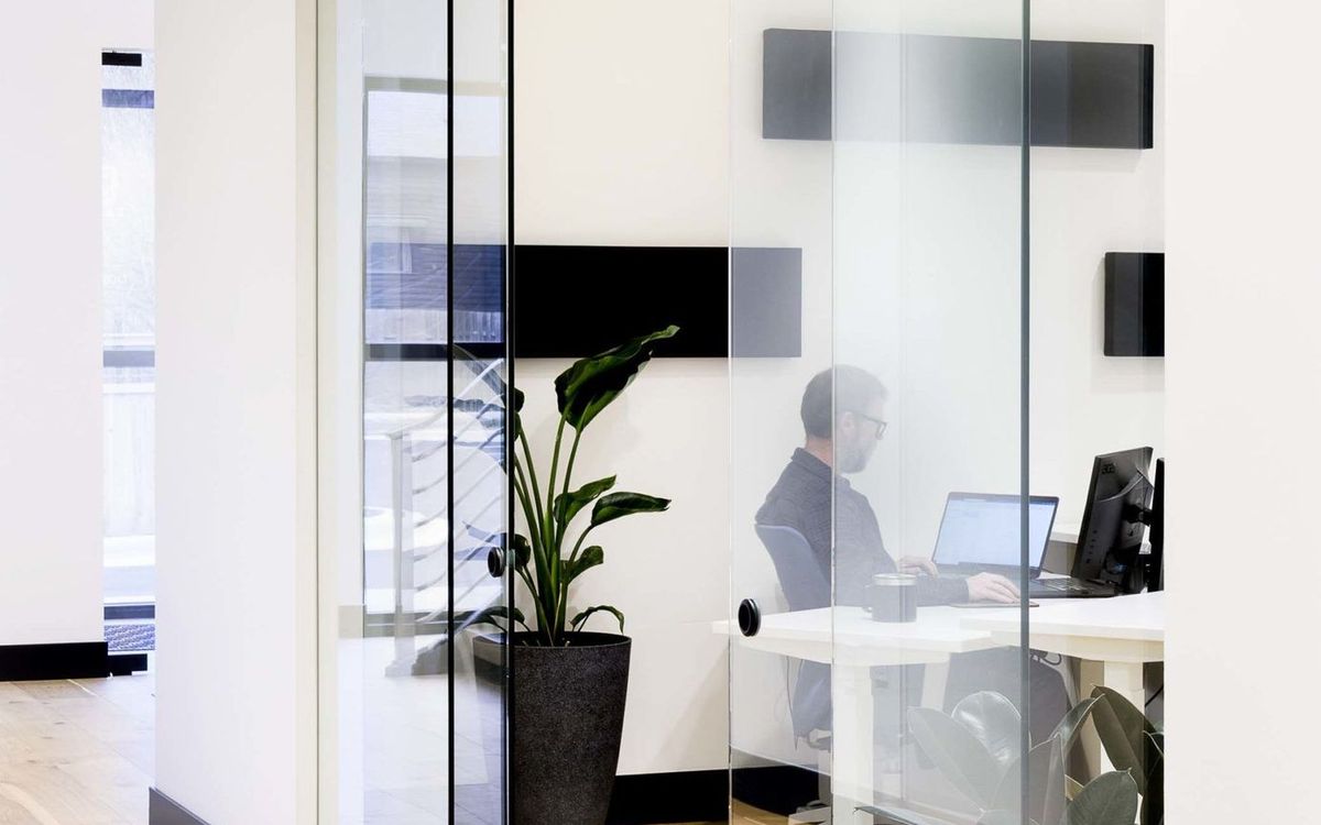 A furnished private office with glass walls