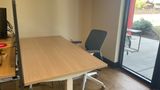 A dedicated desk beside the full-height windows on the downstairs floor, with a sit-stand top and task chair