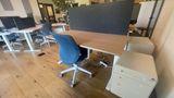 The dedicated desk in context on the downstairs floor, with neighbouring desks and the timber ceiling beyond