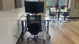 A dedicated desk on the upstairs floor with a 32-inch 4K monitor and task chair