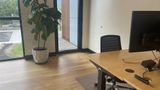 The same dedicated desk from the side, showing the sit-stand frame and floor mat