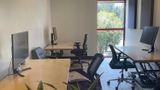 Desks and monitors facing the red-framed window