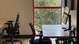 A single workstation at the window, trees outside