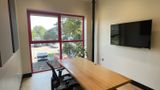 Wall-mounted display above the desk, window to the left