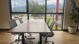 The upstairs hotdesk block with task chairs, looking out to the mountains