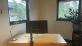 Private Office 10 upstairs — a wooden desk with a monitor, desk lamp and a plant