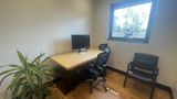 The whole office from the doorway — birch desk, monitor, task chair and guest chair
