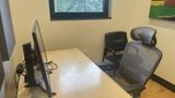 Private Office 9 upstairs — sit-stand desk with a monitor, task chair and a guest chair by the window