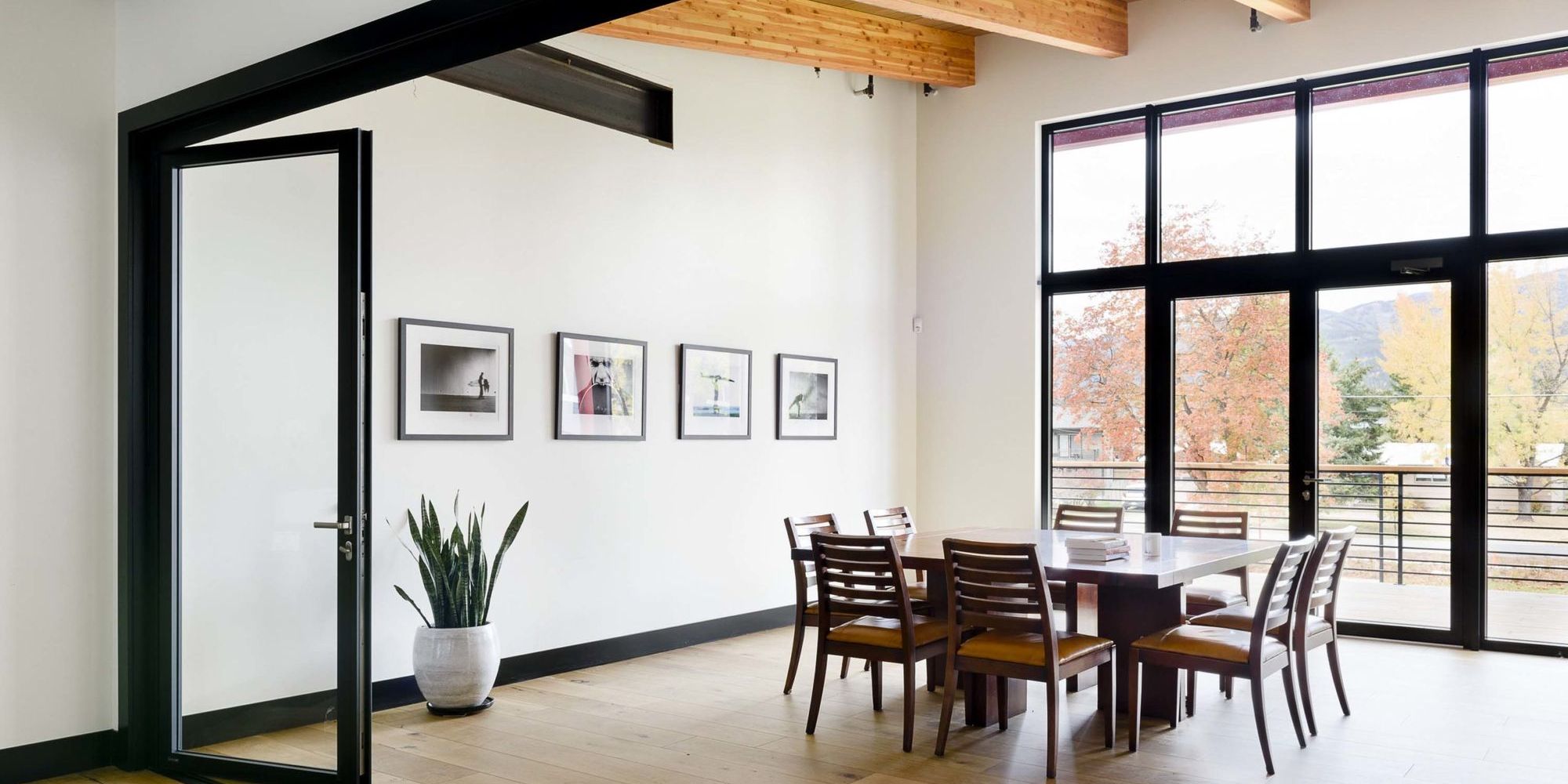 Meeting room with a long wooden table, eight chairs, and framed prints
