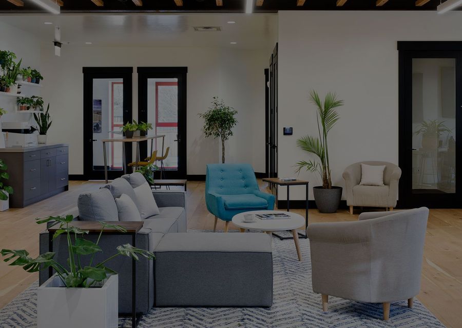 Lounge seating under exposed wood beams with plants and armchairs