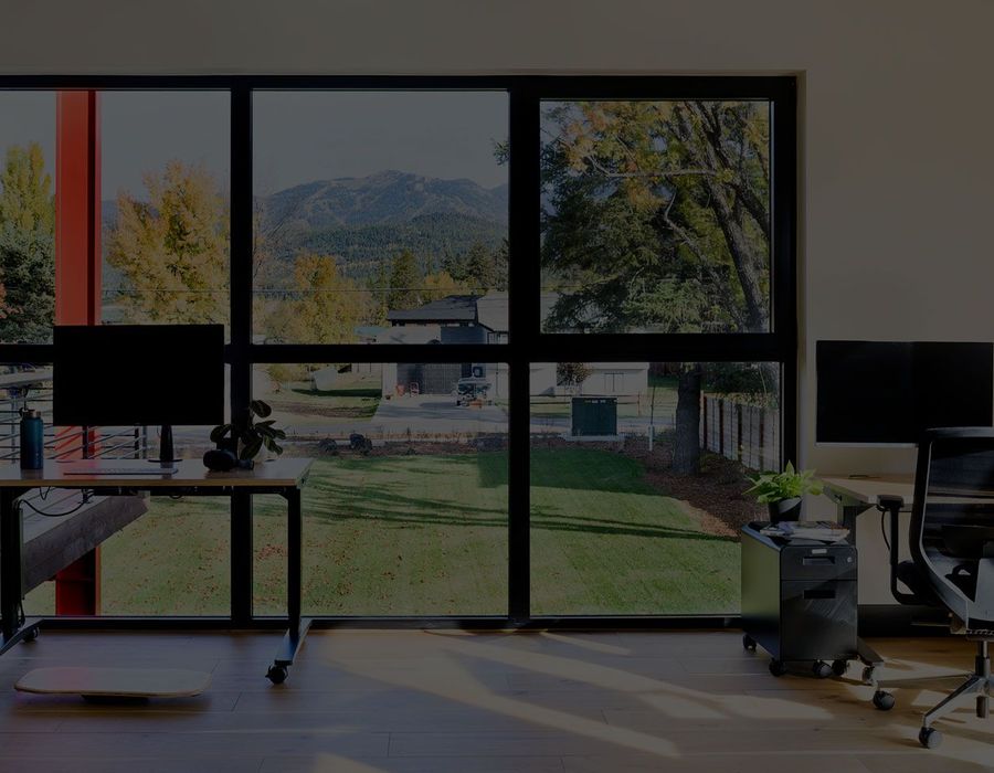 Dedicated desk with dual monitors facing the window