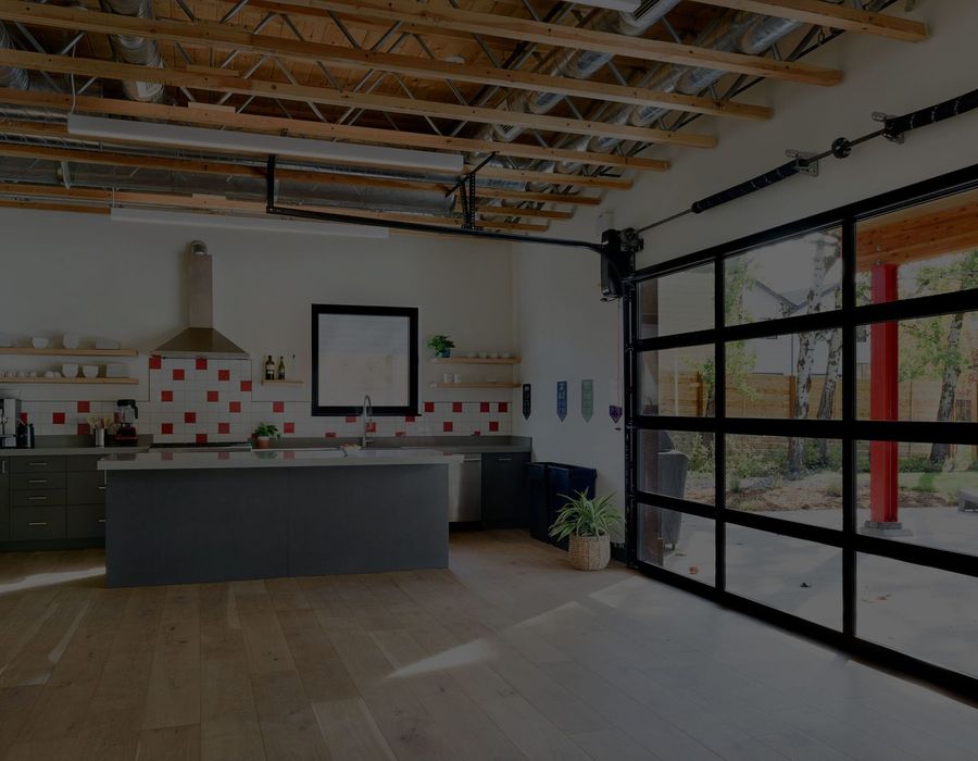Kitchen island and range hood beside glass garage doors