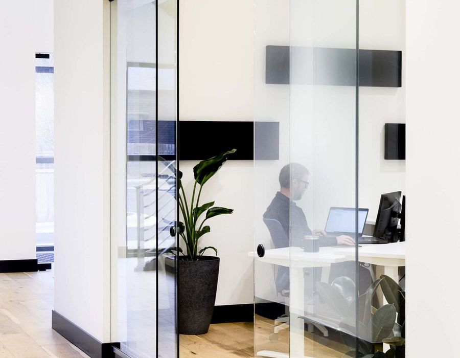Glass-walled private office with a desk and chair