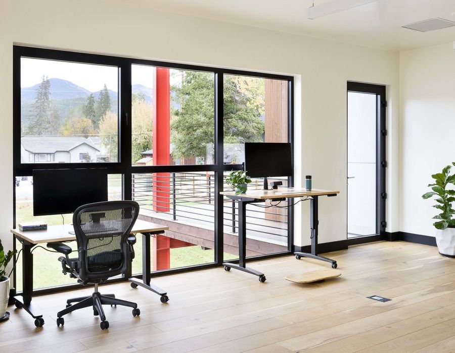 Workstation facing floor-to-ceiling windows and a mountain view